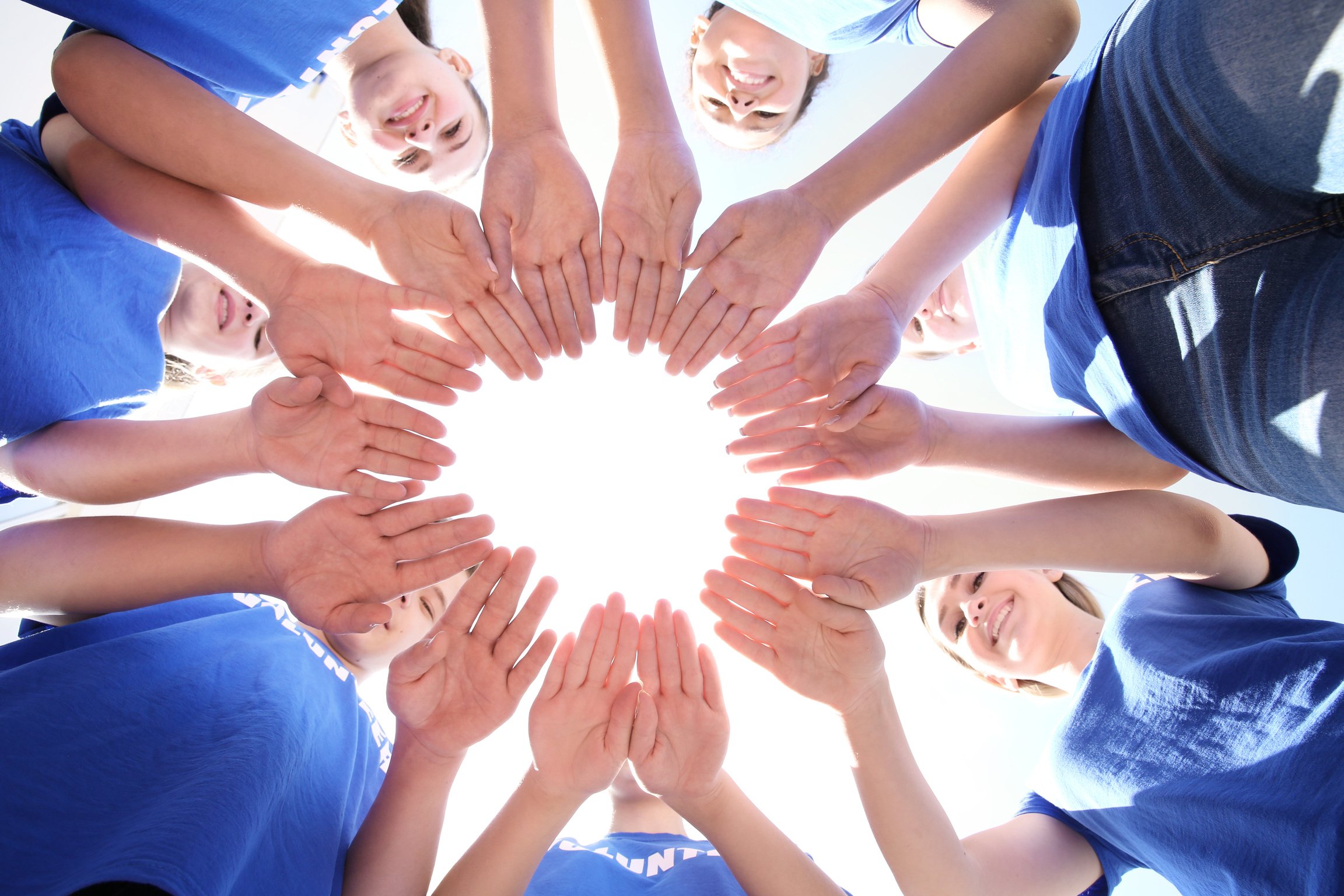 Team of Volunteers Putting Their Hands Together as Symbol of Unity